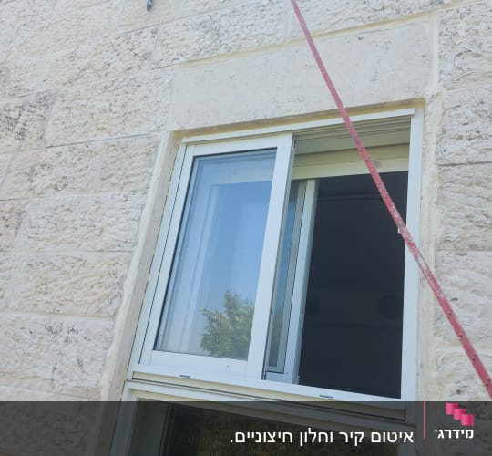 חלון פתוח בקיר אבן עם חבל תלוי